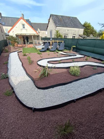 a backyard with a garden with chairs and plants at la parenthèse in Sainte-Mère-Église