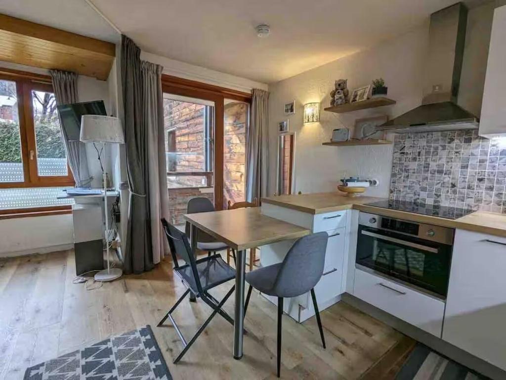a kitchen with a table and chairs in a room at La marmotte namuroise in Saint-Jean-d'Aulps