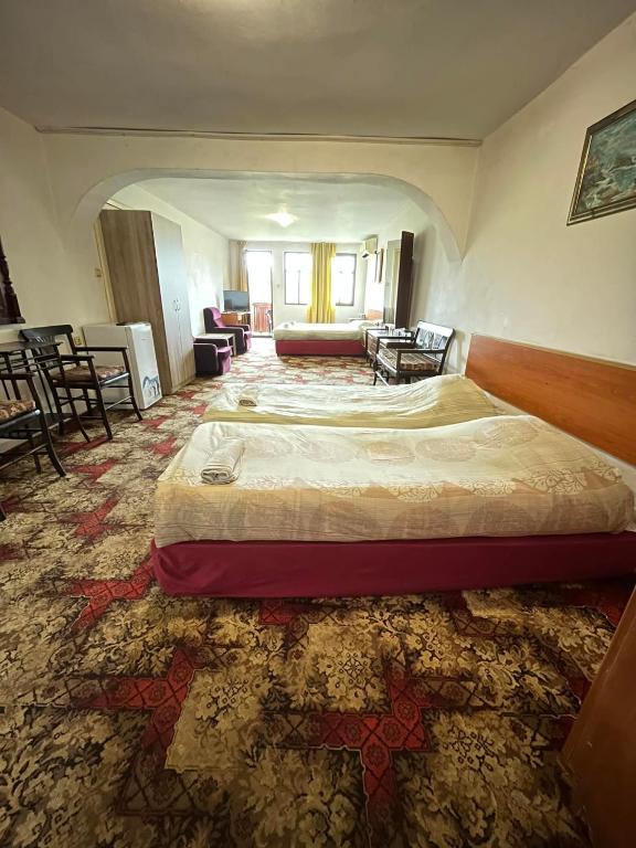 a hotel room with a large bed and a living room at Guestrooms Ross in Veliko Tŭrnovo