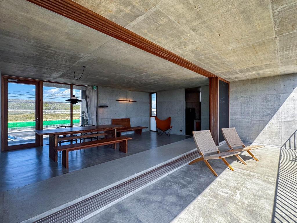 a living room with a wooden table and chairs at 大木の宿 Shicari in Yomitan