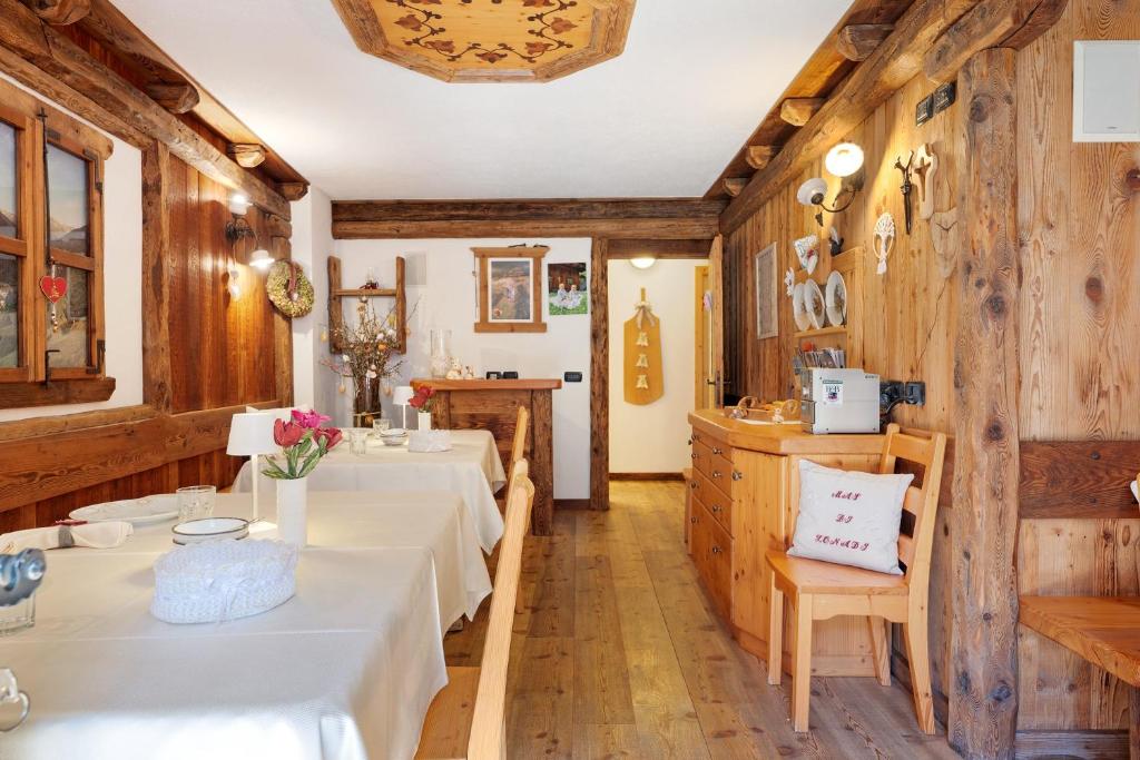 a restaurant with white tables and wooden walls at Mas di Zonadi - intero alloggio in Rabbi