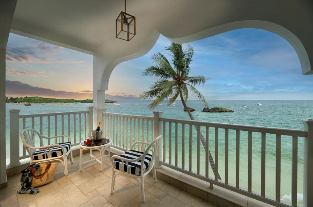 a balcony with a view of the ocean at Hemingways Watamu in Watamu