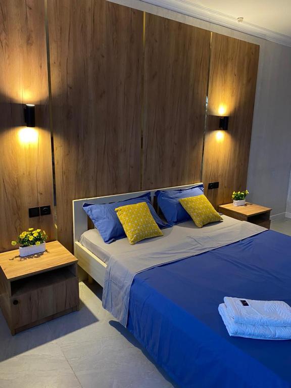 a bedroom with a large bed with blue sheets and yellow pillows at AIDANA гостиница in Oral