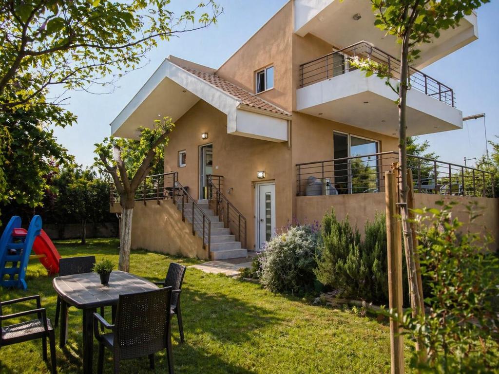 ein Haus mit einem Tisch und Stühlen im Hof in der Unterkunft Enervillas 2030 in Káto Achaḯa