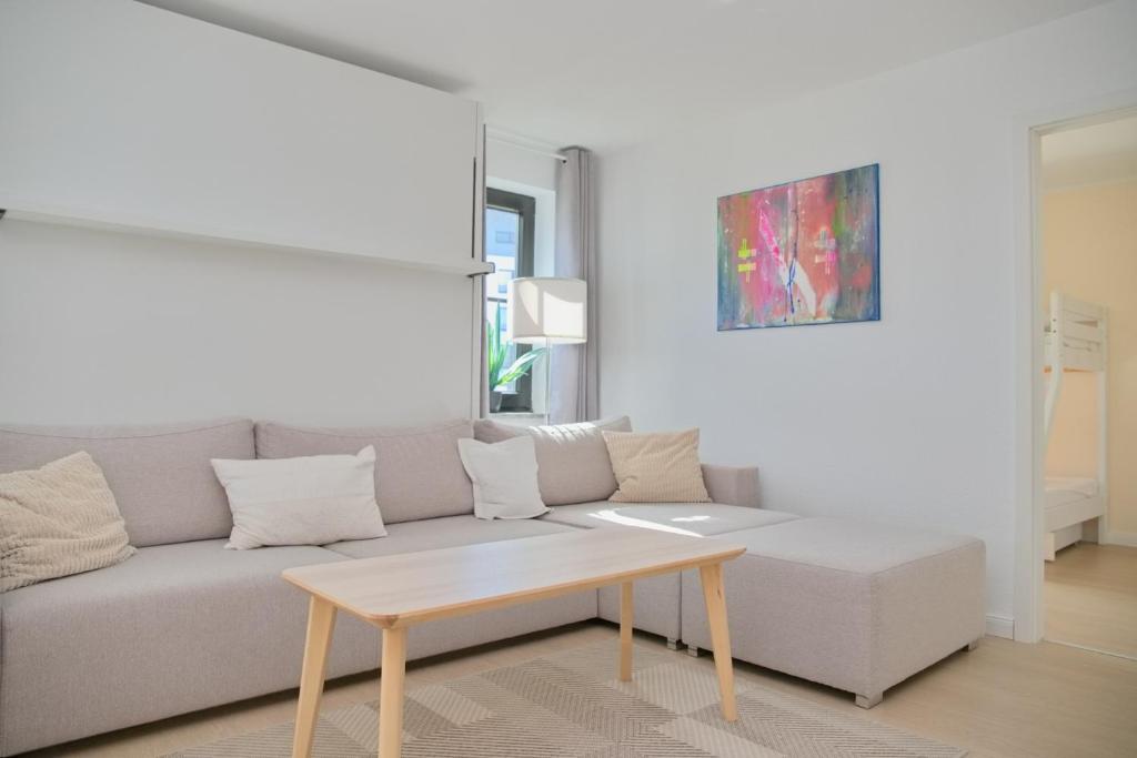 a living room with a couch and a coffee table at Haus Titania App 9 inkl WLAN in Grömitz