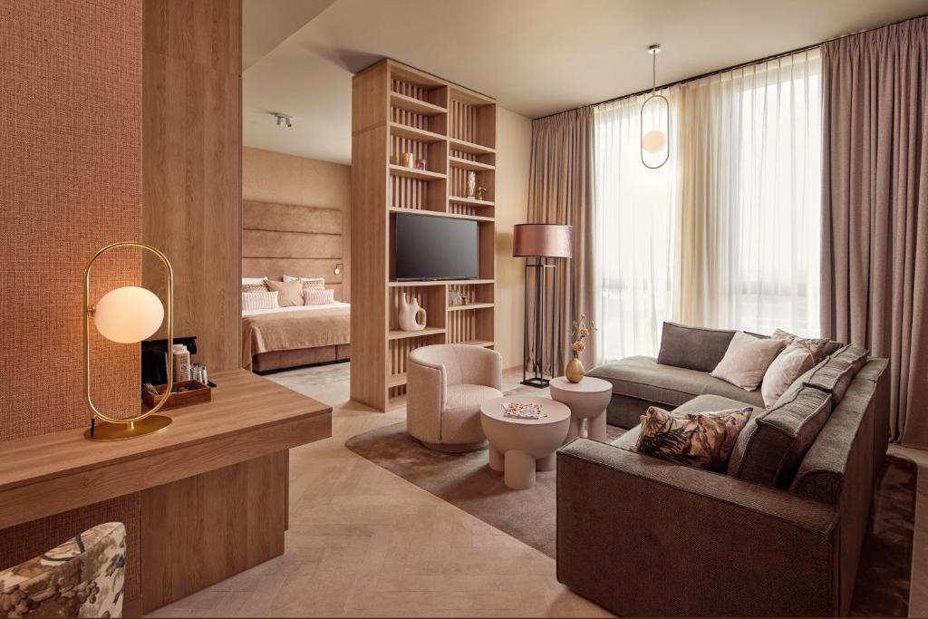 a living room with a couch and a tv at Van der Valk Hotel Gorinchem-A15 in Gorinchem