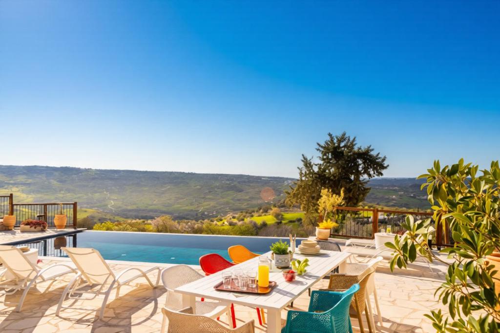 a patio with tables and chairs and a pool at Casale Xenia in Lyso