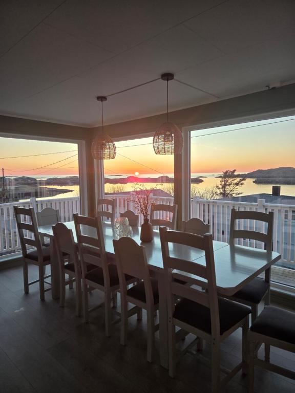 a dining room with a table and chairs with a view at Havblikk in Stø