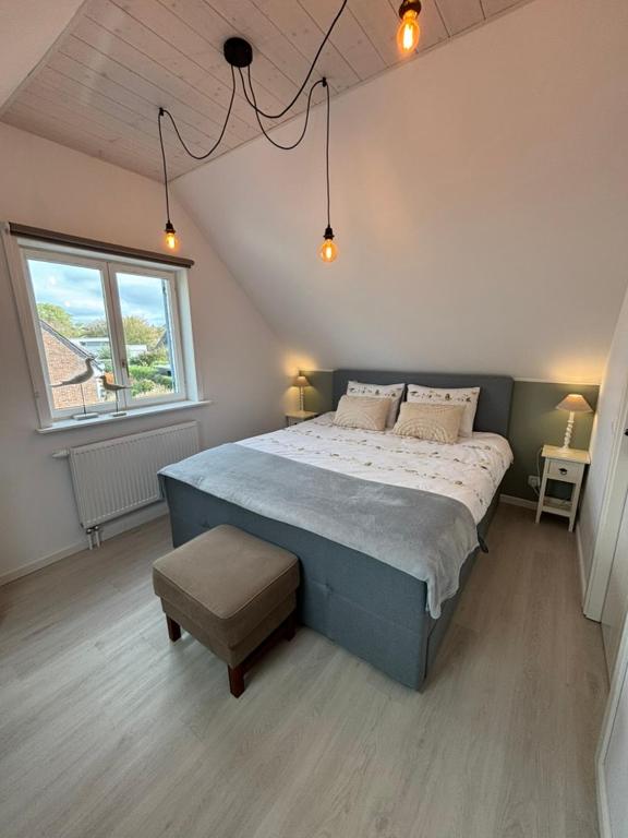 a bedroom with a large bed and a window at De Strandloper B&B Oostduinkerke in Koksijde