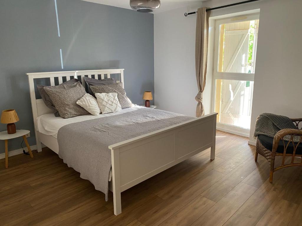 a bedroom with a white bed and a window at LAVAUR Location de meublé saissonier in Labastide-Saint-Georges