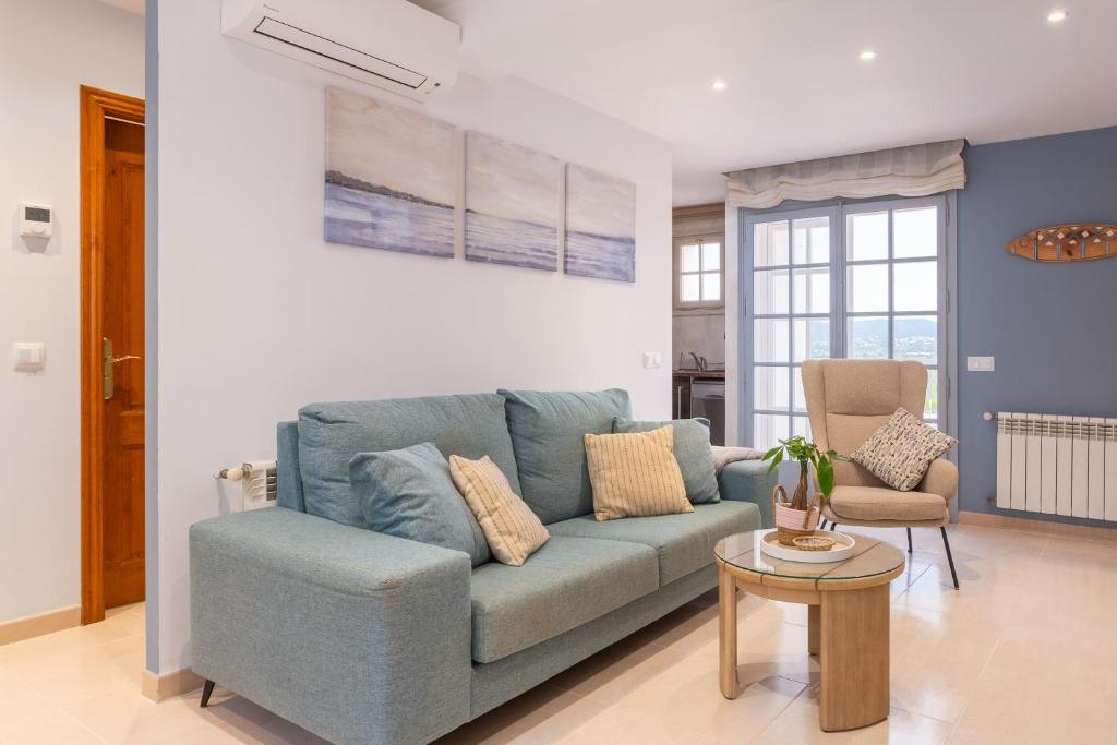 a living room with a blue couch and a table at Apartament Sant Antoni de Calonge in Sant Antoni de Calonge