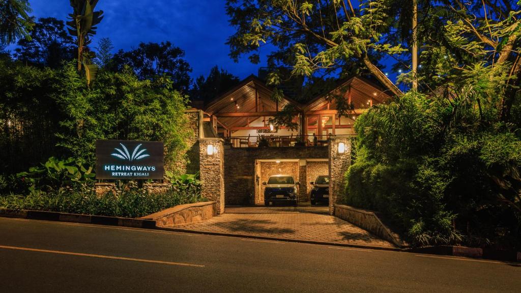 a house with a sign on the side of a road at Hemingways Retreat Kigali in Kigali
