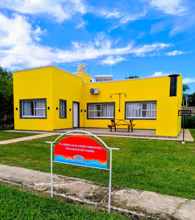 a yellow house with a sign in front of it at Cabañas La Soñada in Chajarí