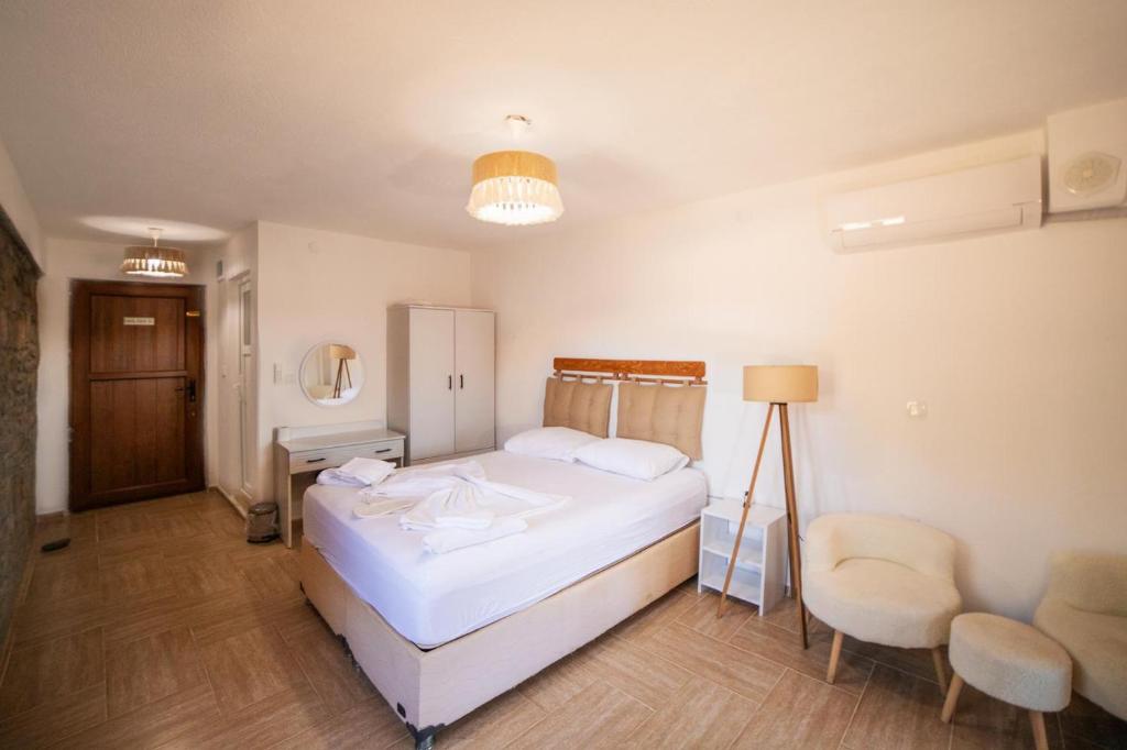 a bedroom with a bed and a table and chairs at kastro konak in Gokceada Town