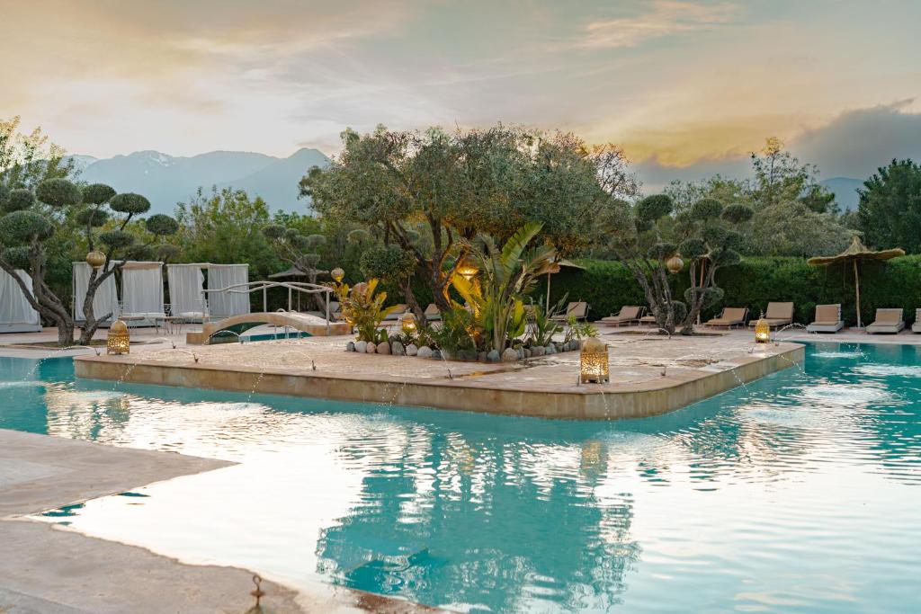 a swimming pool in a resort with trees and mountains at Ksar Shama - Atlas Mountain Retreat in Ouirgane