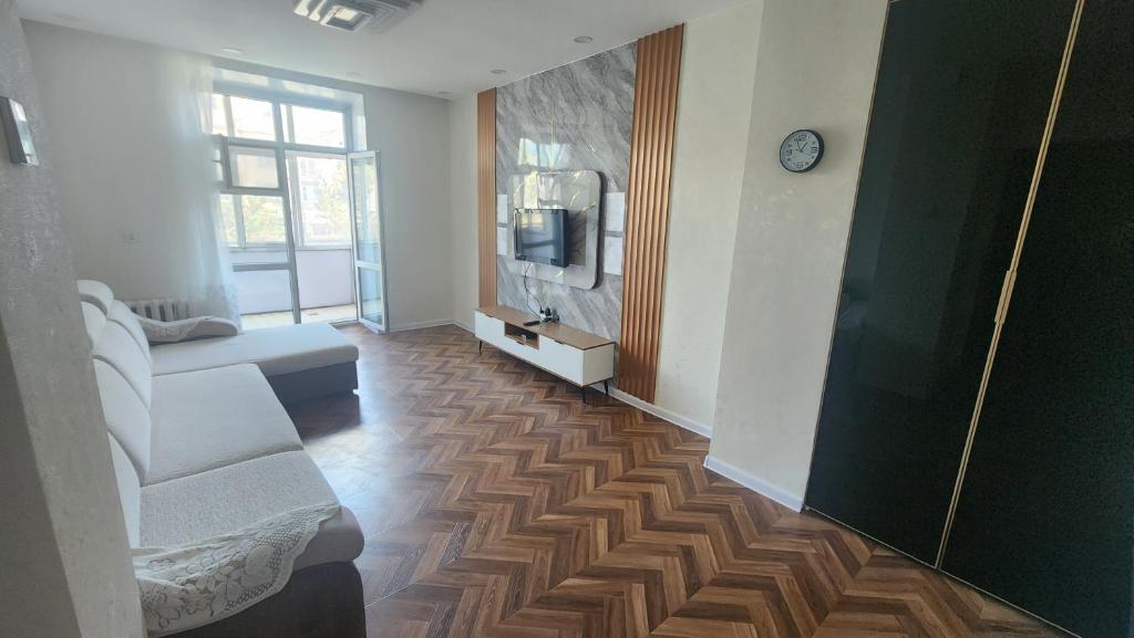 a living room with a couch and a tv on the wall at Guest House 14th in Ulaanbaatar