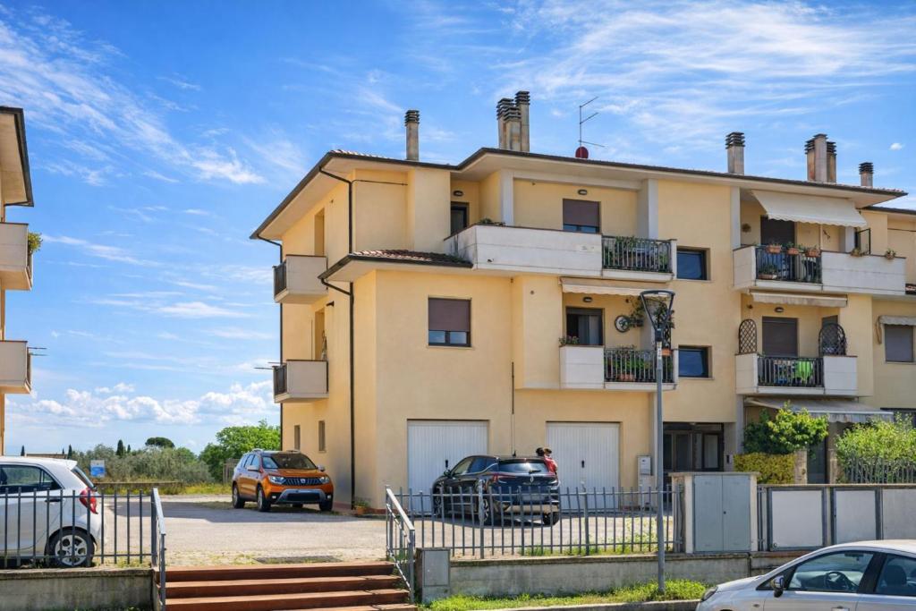 a yellow building with cars parked in front of it at Montecchio di Cortona in Cortona