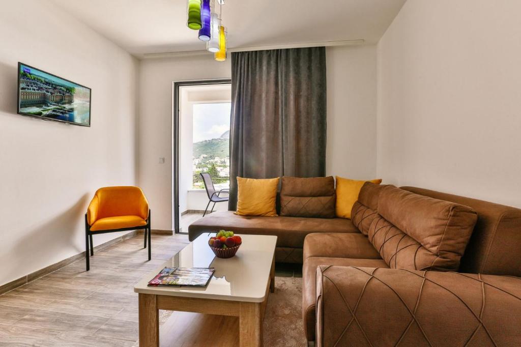 a living room with a brown couch and a table at Lux Apartmani Djukic in Bar