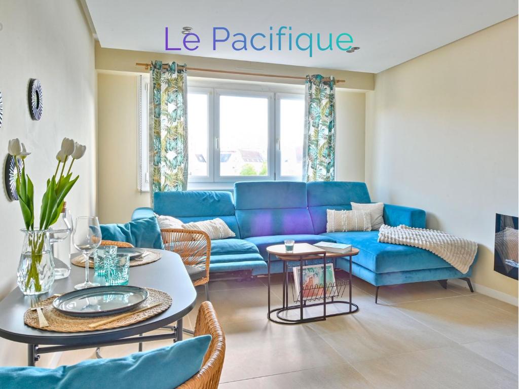 a living room with a blue couch and a table at Le pacifique in Schiltigheim