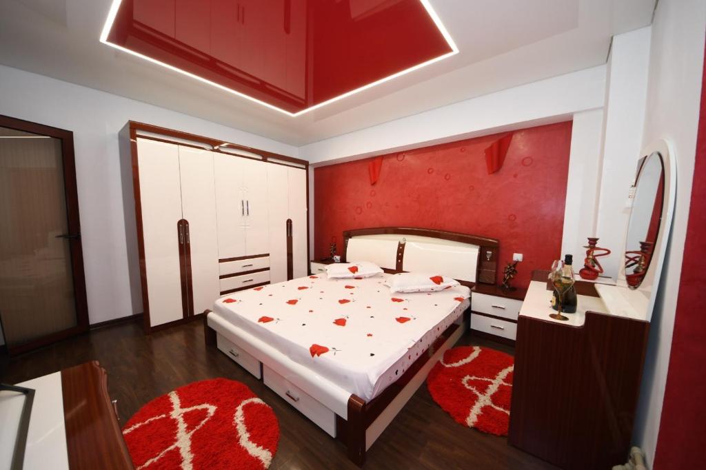 a bedroom with a bed and a red wall at Ket Apartments in Galaţi