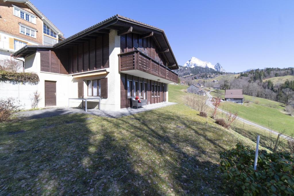 a house on a grassy hill with a building at Chalet Stadel in Unterwasser