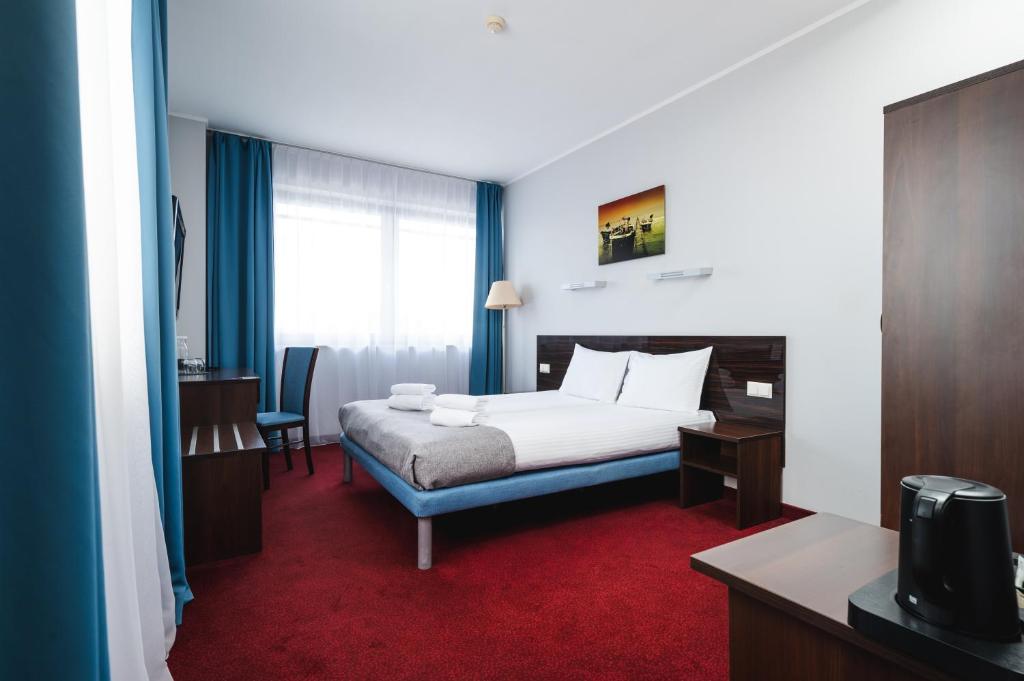 a hotel room with a bed and a desk and chair at Focus Hotel Gdańsk in Gdańsk