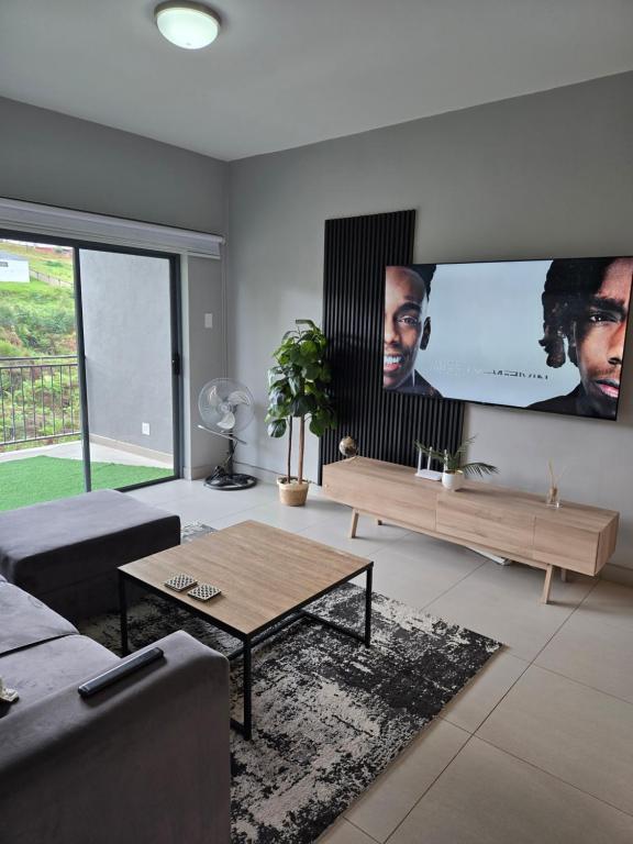 a living room with a couch and a tv at WeThusiCBD in Mbabane
