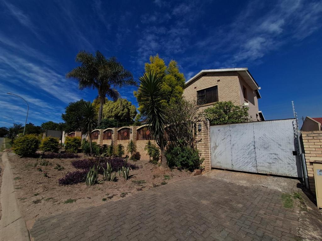 a house with a fence and a driveway at Emakhaya B&B in Mthatha