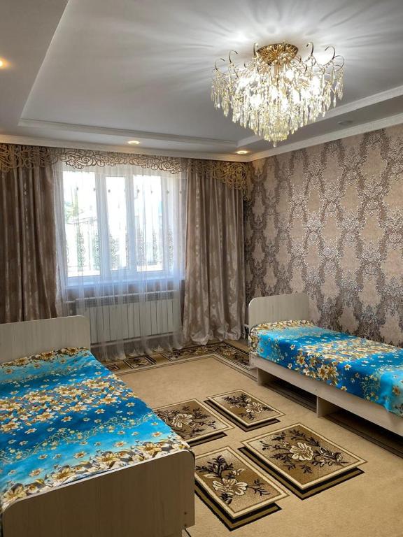 a bedroom with two beds and a chandelier at Daniel guesthouse in Kochkorka