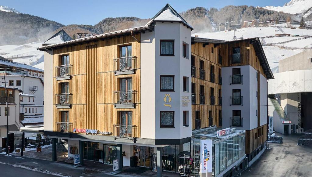 a building in the middle of a town with snow at Glanz & Glory Hotel in Sölden