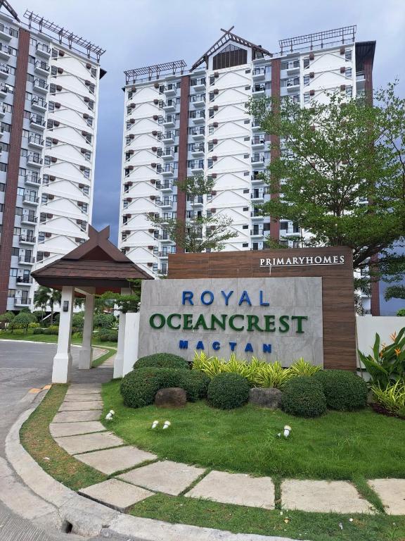 a sign in front of two tall apartment buildings at Royal oceancrest mactan in Mactan Island
