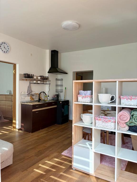 a living room with white shelves with dishes on them at Mazā Roma in Ventspils