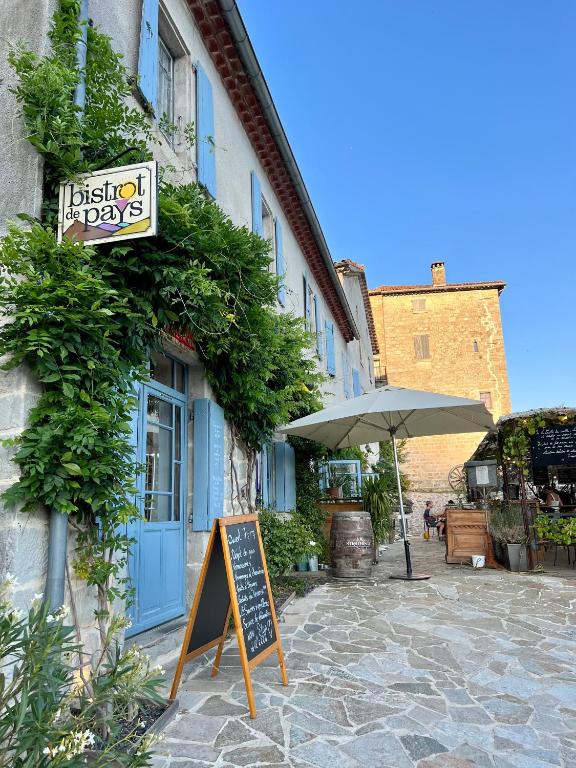 a sign on the side of a building with an umbrella at Gite de La Cueille - Chambre double in Ribes