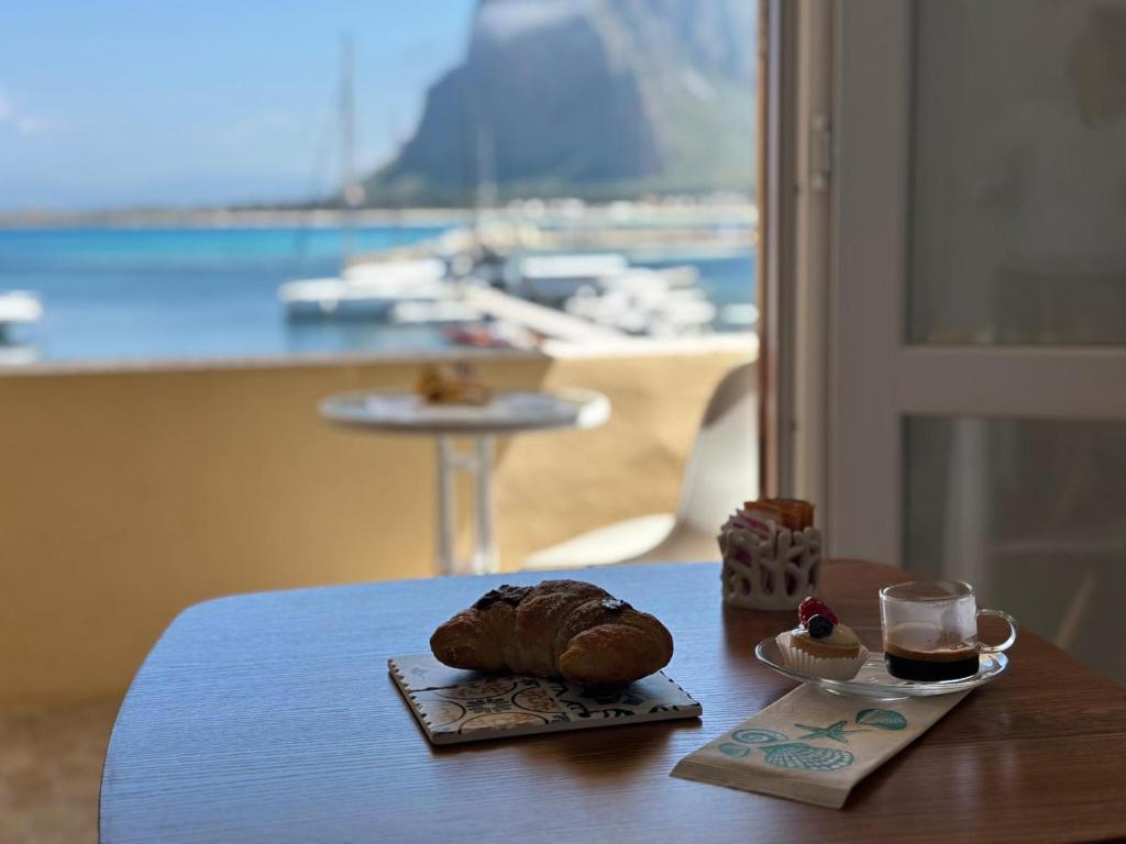 a table with a pastry on top of a table with a window at Il vecchio e il mare in San Vito lo Capo