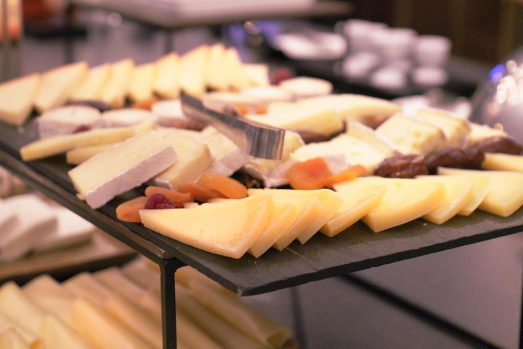 A close-up shows a cheese-and-charcuterie breakfast platter.