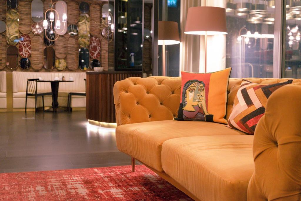 A deep mustard sofa anchors a richly decorated hotel lounge.
