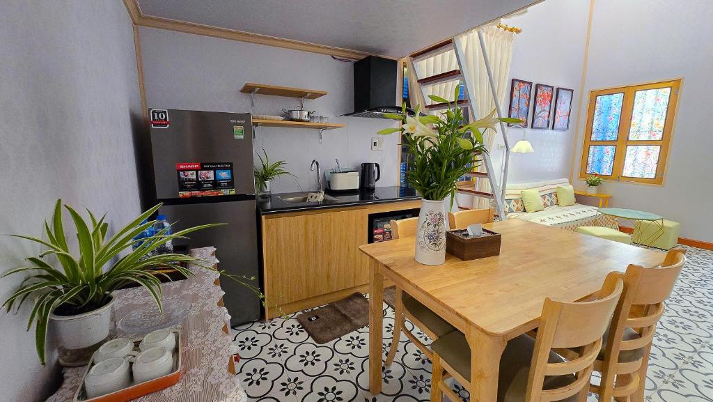 a kitchen and dining room with a wooden table with plants at AM's Home in Ninh Binh