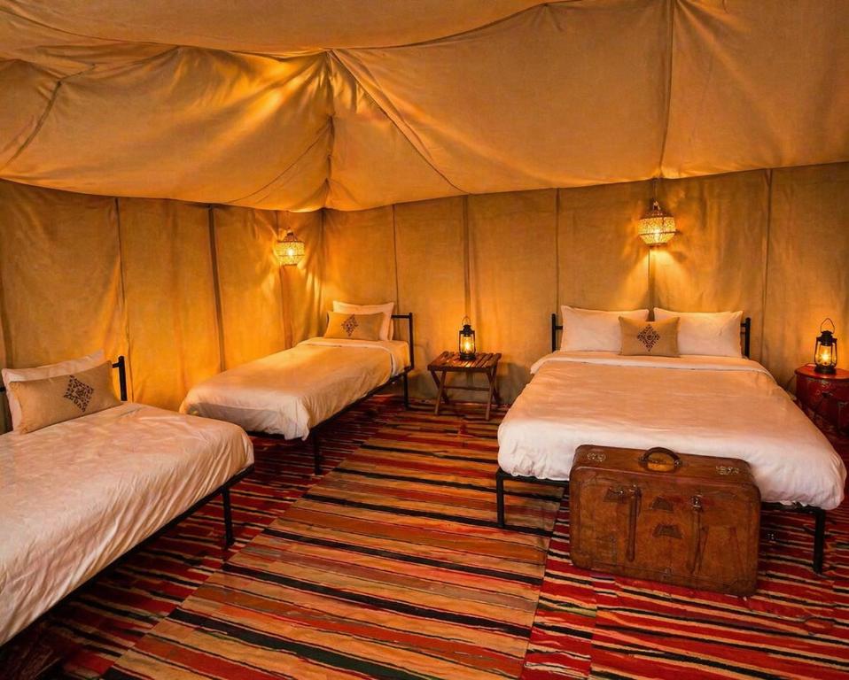 a room with three beds in a tent at Campement authentique désert d Agafay in El Moukhtar