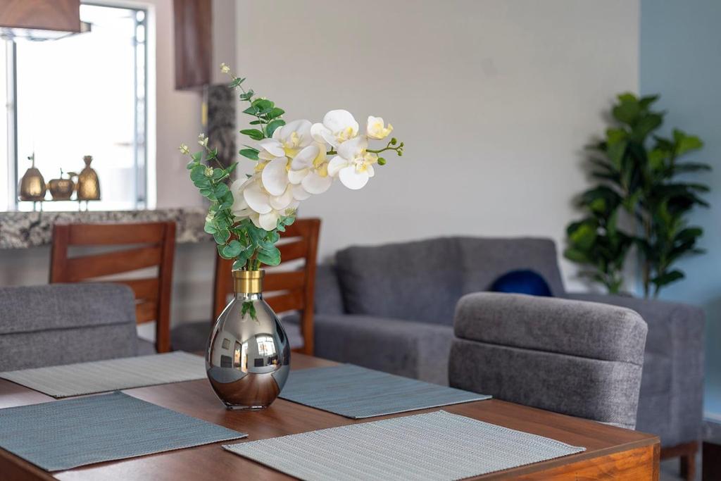 a vase with flowers on a table in a living room at Casa independencia in Morelia