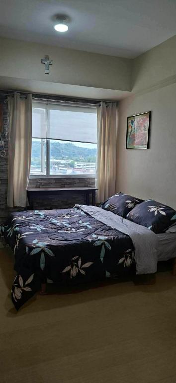 a bedroom with a large bed and a window at Avida Towers Aspira Studio Condo in Cagayan de Oro