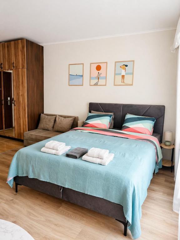 a bedroom with a large bed with towels on it at Studio Moré in Shkorpilovtsi
