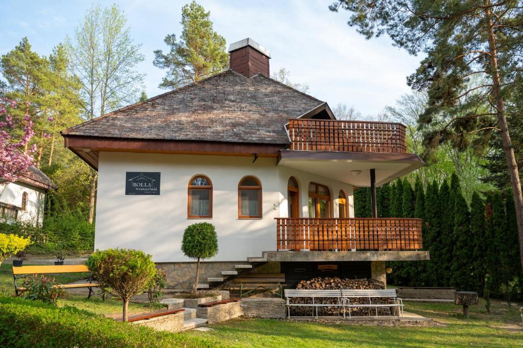 a house with a wrap around porch with a deck at Bolla Nyaralóház in Hegyhátszentjakab