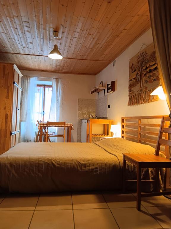 a bedroom with a bed and a wooden ceiling at La Casa Antica in Pont-Saint-Martin
