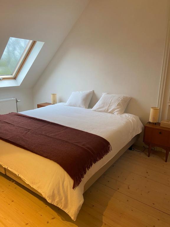 a large bed in a room with a window at Annasroom in Kortrijk