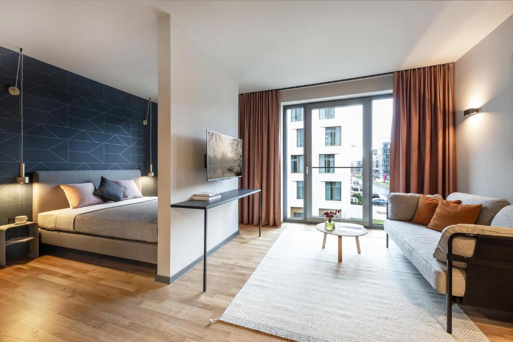 a living room with a bed and a couch at ipartment Darmstadt HOME by Best Western in Darmstadt
