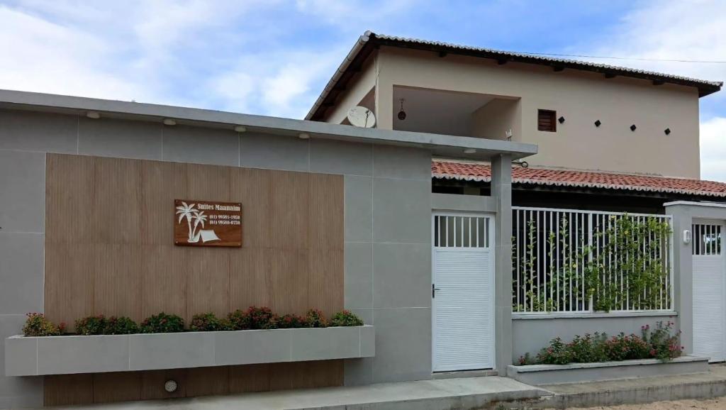 a house with white doors and a fence at Suítes Maanaim Flecheiras in Flecheiras