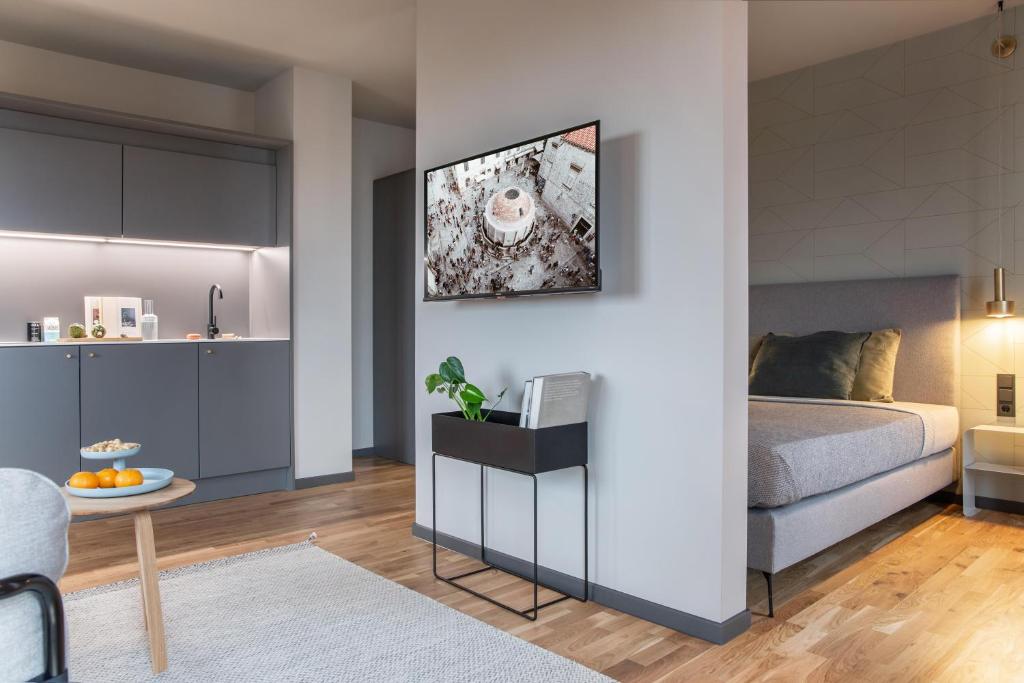 a living room with a bed and a kitchen at ipartment Berlin Airport HOME by Best Western in Schönefeld
