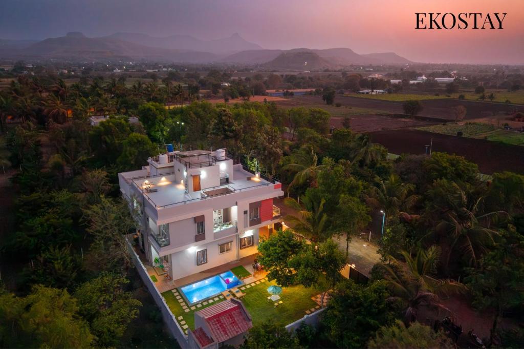 an overhead view of a large white house with trees at EKOSTAY Gold - Vanamora Villa in Pandhurli