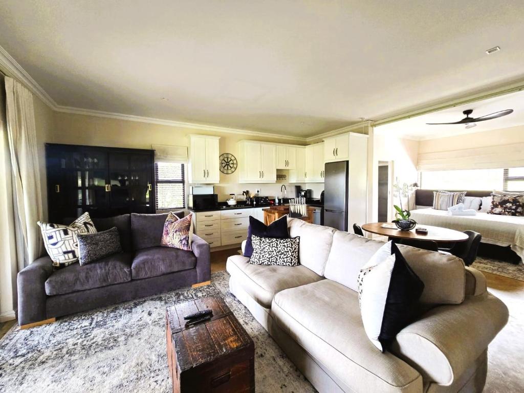 a living room with two couches and a kitchen at Fairfax Studio in Nottingham Road