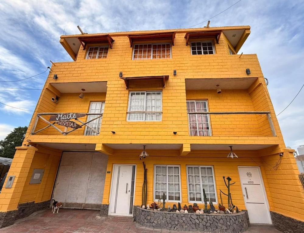 a yellow building with windows on the side of it at Maité Hospedaje in Santa María